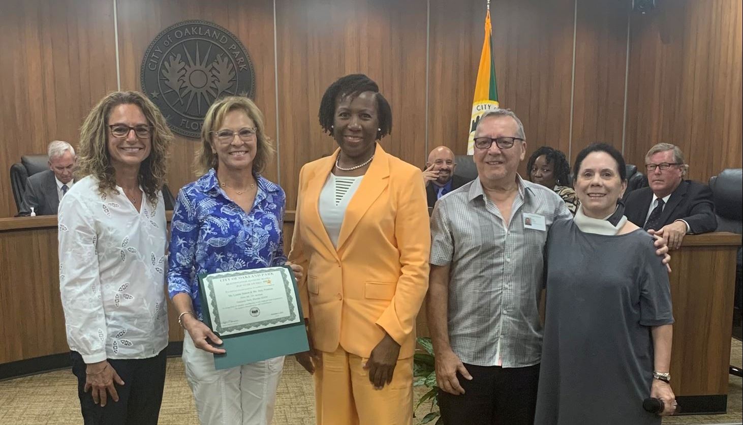 Photo of residents being presented with award certificate at Commission Meeting
